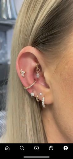 a woman with blonde hair is wearing an ear cuff and has three small diamonds on it