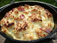 a close up of a pie in a pan on a table outside with grass behind it