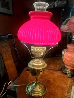 a pink lamp sitting on top of a wooden table