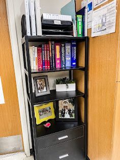 a bookshelf filled with lots of books next to a wall mounted file cabinet