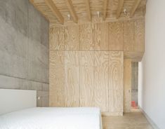 a bed sitting in a bedroom next to a wooden wall