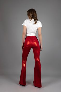 "All eyes will be on you as you perform in these red-hot leggings with flared legs. They are made with mystique spandex to give you the stretch you need to show off your moves on stage. You'll be comfortable in the high waist with 4 cm wide elastic. The back has a V-cut shape with pockets, while the front is solid red. Features: * Tight-fit * Slip-on * High waist * Bell bottom legs * Shiny red mystique spandex, 80% nylon, 20% spandex * V-cut shaped back & pockets * Solid red front * 4 cm wide waistband * 4-way stretch * The model is 179 cm and wearing a size XS x 36\" * Fits true to size. Take your regular size. Available in size XS-XXL. Hip measurement (measures on the actual hip bone:/low waist): XS: 75-80 cm / 29,5\" - 31,5\" S: 81-86 cm / 31,8\" - 33,8\" M: 87-92 cm / 34,2\" - 36,2\" L High Stretch Full Length Red Leggings, Full-length Red Elastane Pants, Red Full-length Elastane Pants, Full Length Red Pants, Red Fitted Full Length Bottoms, Fitted Full-length Red Bottoms, High Stretch Red Party Bottoms, Red High Stretch Bottoms For Party, High Stretch Red Bottoms For Party