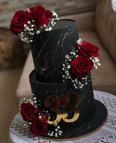 a three tiered black cake with red roses on top and the number 350 written on it