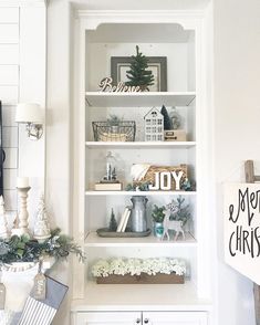 a white book shelf filled with christmas decorations