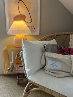 a wicker chair with pillows on it in front of a lamp and other items