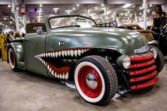 an antique car with large teeth painted on it's front fenders and sides