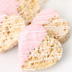 rice krispie valentine hearts with white icing and pink frosting on top are shown