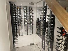 a wine cellar filled with lots of bottles next to a stair case full of wine