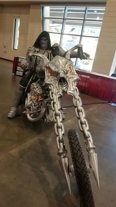 a person on a motorcycle with chains attached to it's handlebars in a building