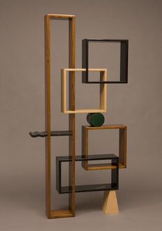 an abstract sculpture made out of wood and metal with black, green and white squares