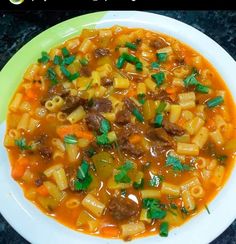 a white bowl filled with pasta and meat soup