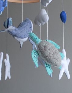 a baby mobile with sea animals hanging from it's sides and an ocean theme