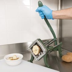 a person in blue gloves is peeling an apple into a slice with a peeler