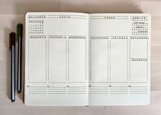 an open planner with two pencils on it