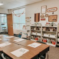 an empty classroom with desks and bookshelves in front of the window,