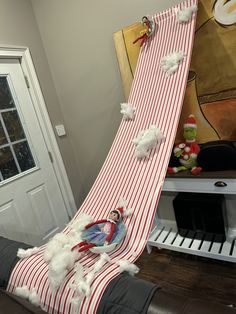 an elf slides down a slide in the living room