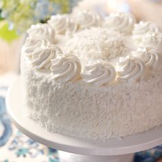 a close up of a cake on a plate with flowers in the backgroud