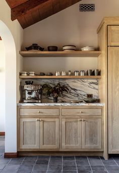 a kitchen with wooden cabinets and marble counter tops