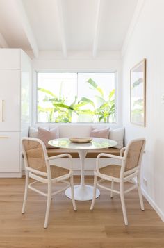 a white table and chairs in front of a window