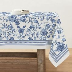 a blue and white table cloth on top of a wooden bench