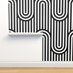 an abstract black and white wallpaper with wavy lines in the center, on a wooden floor