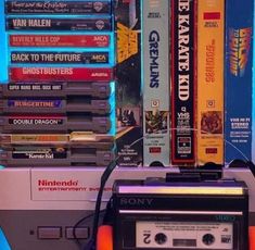 an old school cassette player sitting next to a stack of video games