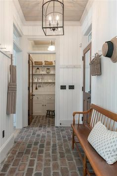 a wooden bench sitting in the middle of a hallway next to a white wall and door