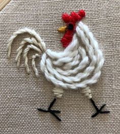 a close up of a rooster on a piece of fabric