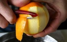 a person is peeling an orange into pieces