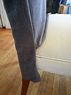 a person standing on top of a wooden floor next to a bed