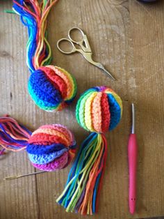 crocheted balls of yarn, scissors and thread on a wooden table with craft supplies