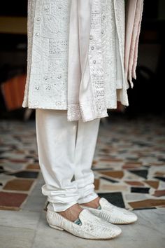 Ivory woven sherwani with mandarin collar, all over mixed pattern, sequin and tonal thread embroidery. Paired with cotton silk kurta, churidar and stole with embroidered border.
Components: 4
Pattern: Embroidered and Woven
Type Of Work: Thread and Sequin Work
Neckline: Mandarin Collar
Sleeve Type: Full Sleeves
Fabric: Cotton Silk, Lining: Viscose Poly
Color: Ivory
Other Details: 
Front and side slits
Attached lining
Sherwani Closure: Front concealed placket
Note: The safa, kalangi and mala worn Festive White Churidar With Naqshi Detailing, Designer White Churidar With Naqshi Detailing, White Naqshi Churidar For Festivals, White Raw Silk Nehru Jacket With Dabka, White Dabka Churidar For Traditional Ceremonies, Transitional White Naqshi Churidar, Off White Sherwani With Chikankari Embroidery For Transitional Season, Traditional Off White Bandhgala With Chikankari Embroidery, Traditional Off White Nehru Jacket With Naqshi