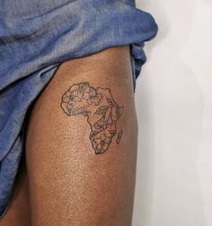 a woman's leg with a tattoo on it, showing the map of africa