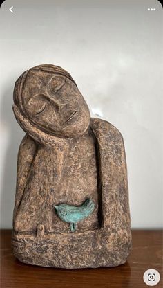 a stone statue sitting on top of a wooden table