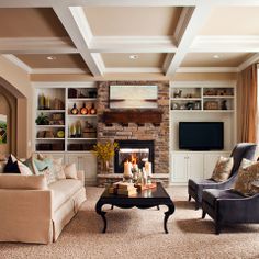 a living room filled with furniture and a flat screen tv mounted on a wall above a fire place