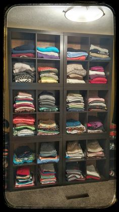 a closet filled with lots of folded clothes