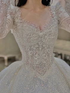 a woman in a wedding dress is holding her hands up to her head and looking at the camera