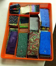 an orange container filled with lots of different types of ties on top of a table