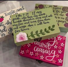 three wooden boxes with writing on them sitting on top of a white tablecloth covered table