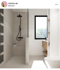 a bathroom with a toilet, sink and shower head in it's center wall