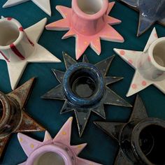 several ceramic stars and vases on a table