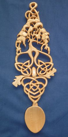 an intricately designed wooden brooch with a tree on it