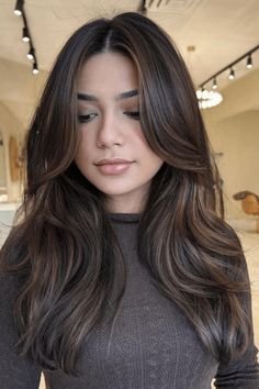 This contemporary, understated balayage technique for dark tresses showcases seamless, natural-looking highlights that blend flawlessly, creating a refined appearance. The soft waves and face-framing layers add movement and depth, beautifully enhancing the rich, dark base color. This chic and - Click to see more of Captivating Balayage Transformations for Ebony Tresses: 30 Breathtaking Looks to Elevate Your Style and follow us for more hairstyle ideas. // Photo Credit: Instagram @faryaldoeshair Dark Brunette With Subtle Highlights, Winter Dark Brown Hair, Dimensional Brunette Medium Brown, Rich Dark Chocolate Brown Hair Balayage, Dark Hair Balayage Cool Tones, Black Hair Natural Highlights, Natural Highlights On Dark Brown Hair, Dark Balyage Long Hair Brunettes, Cool Dark Brown Hair With Highlights