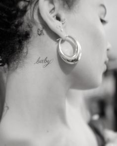 a woman with a small tattoo on her neck and the word baby written in cursive font