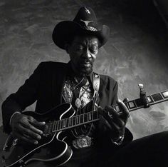 a man in a cowboy hat playing an electric guitar