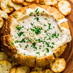 baked potato chips with sour cream dip in the middle on a wooden plate surrounded by crackers