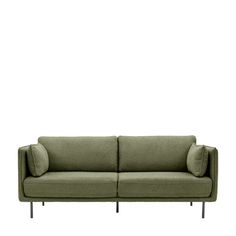 a green couch sitting on top of a white wall next to a black metal frame