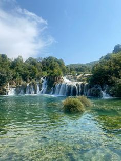 the water is crystal green and there are many waterfalls in the backrounds