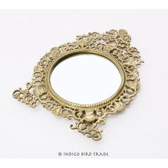 an ornate gold mirror is shown against a white background