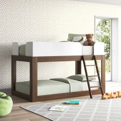 a child's bedroom with a bunk bed and green chair next to the window